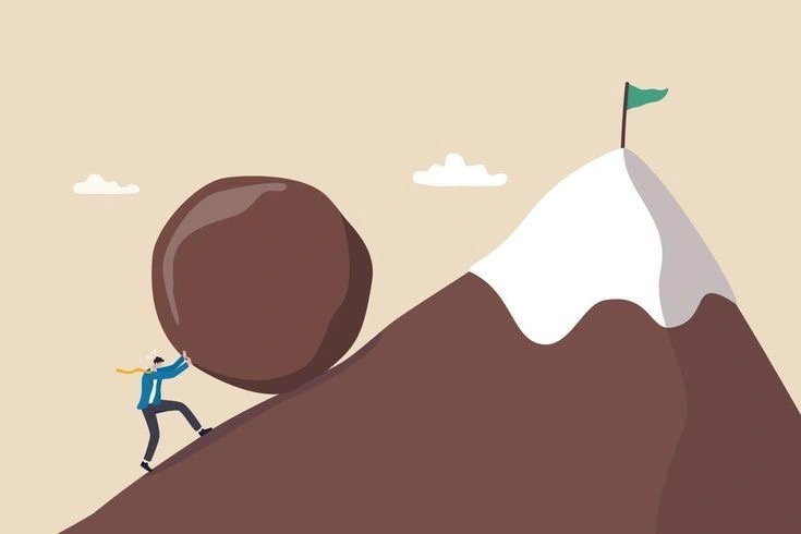 An illustration of a person pushing a large boulder up a steep mountain toward a summit marked with a flag, symbolizing effort, perseverance, and the struggle to achieve a goal.