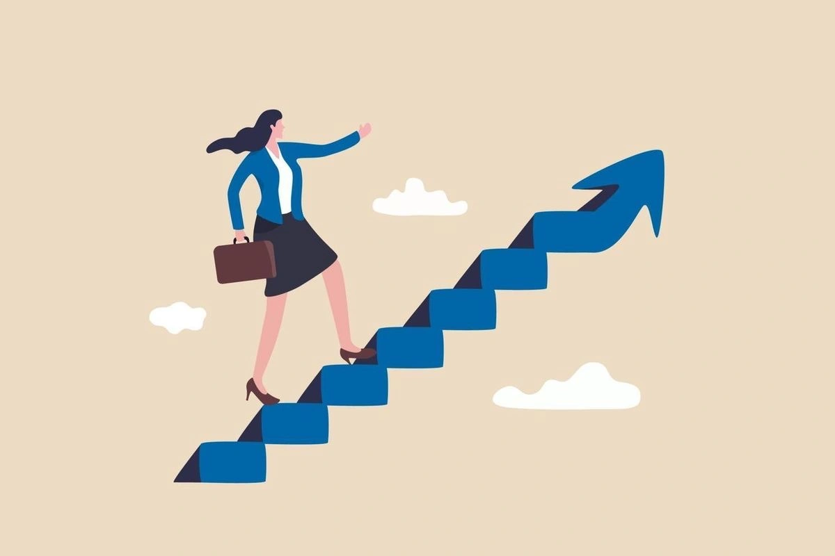 A flat illustration of a businesswoman climbing upward on stairs shaped like an arrow, holding a briefcase and reaching forward, symbolizing career growth, ambition, and progress toward success.
