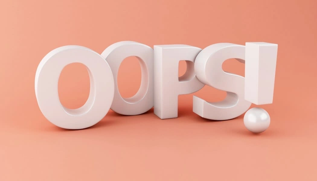 The word “OOPS!” in large white 3D letters on a soft peach background, conveying a sense of mistake, surprise, or playful error.