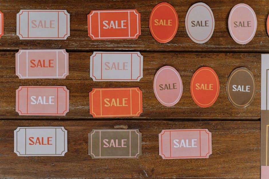 Various sale tags on a wooden surface ideal for retail marketing and promotions.