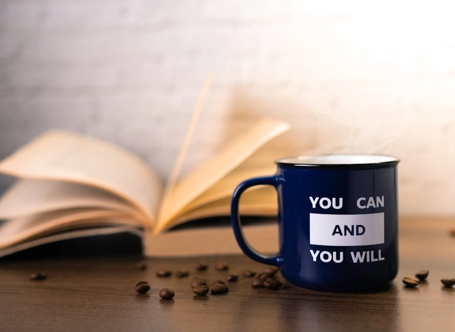 Motivational mug with an open book and coffee beans, perfect for inspiring your day.