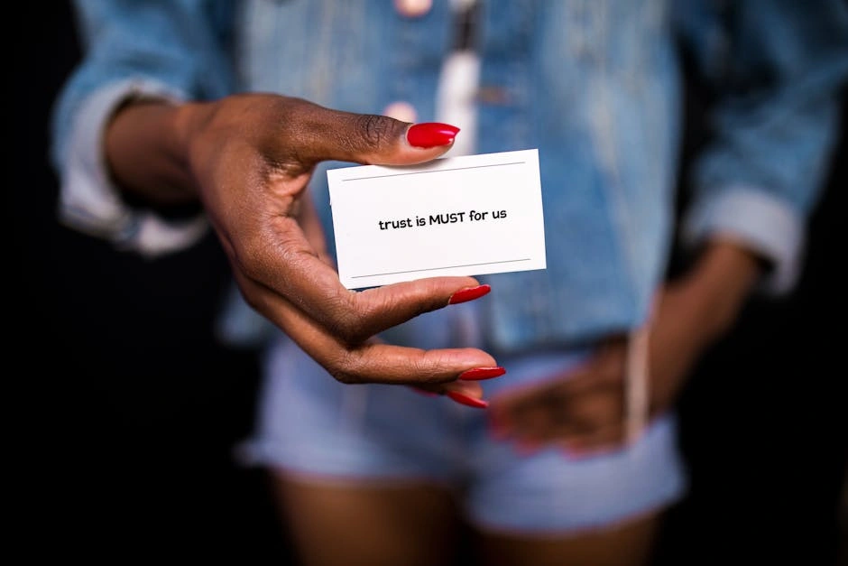 A close-up image of a hand holding a card with the message 'trust is MUST for us.'