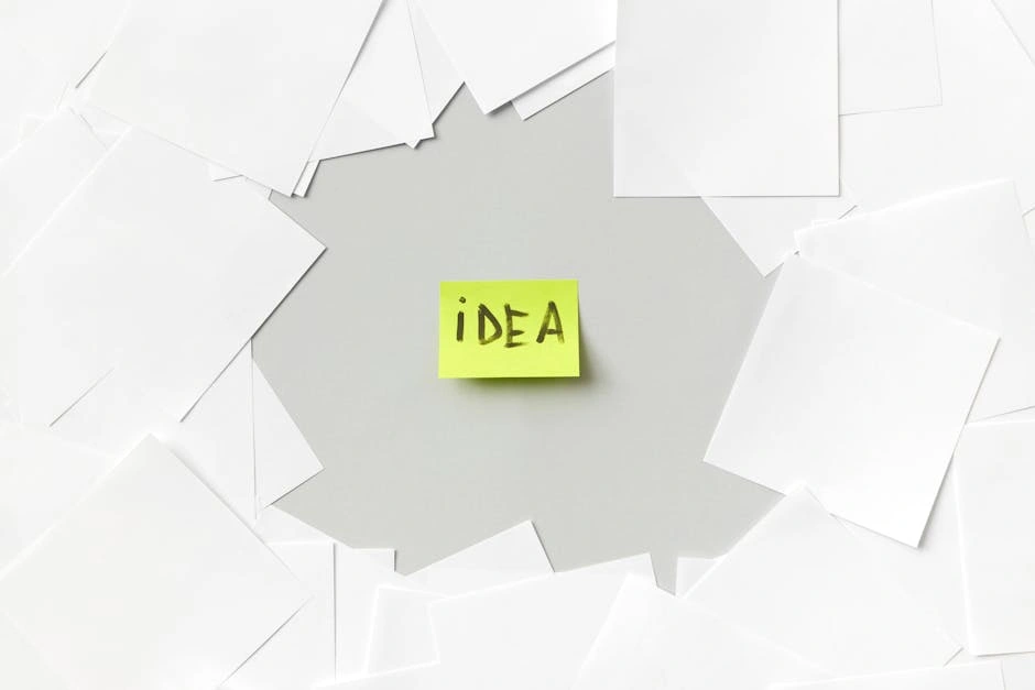 Yellow sticky note labeled 'Idea' surrounded by white papers, symbolizing creativity.