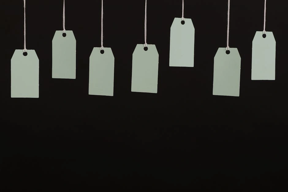 Multiple blank tags hanging on strings against a black background, ideal for designs.