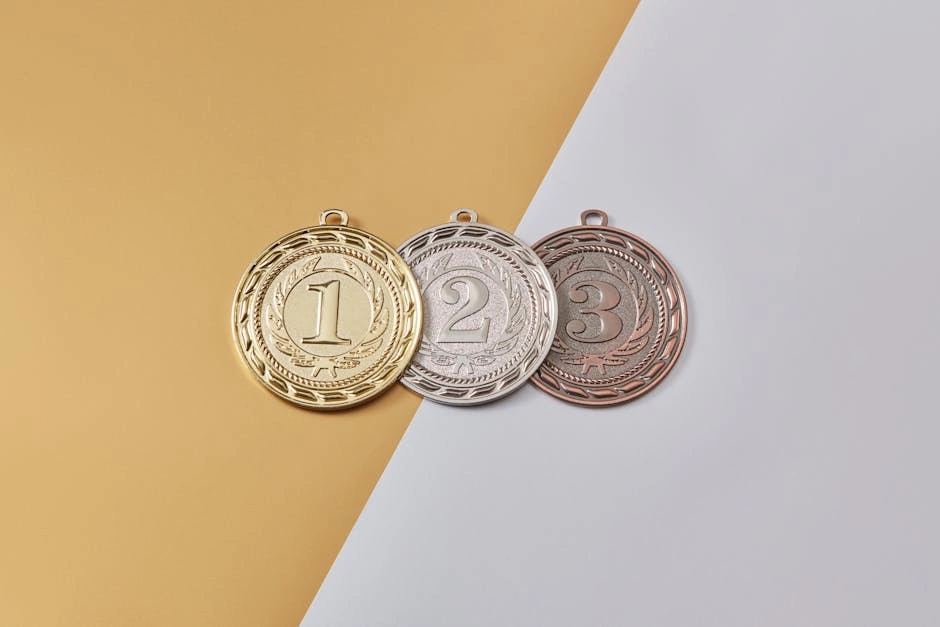 Gold, silver, and bronze medals placed on a modern split-color background, symbolizing achievement.