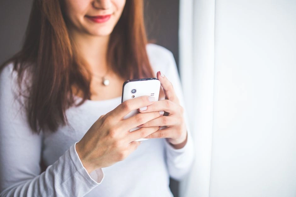 Woman typing a message to a client on her smartphone