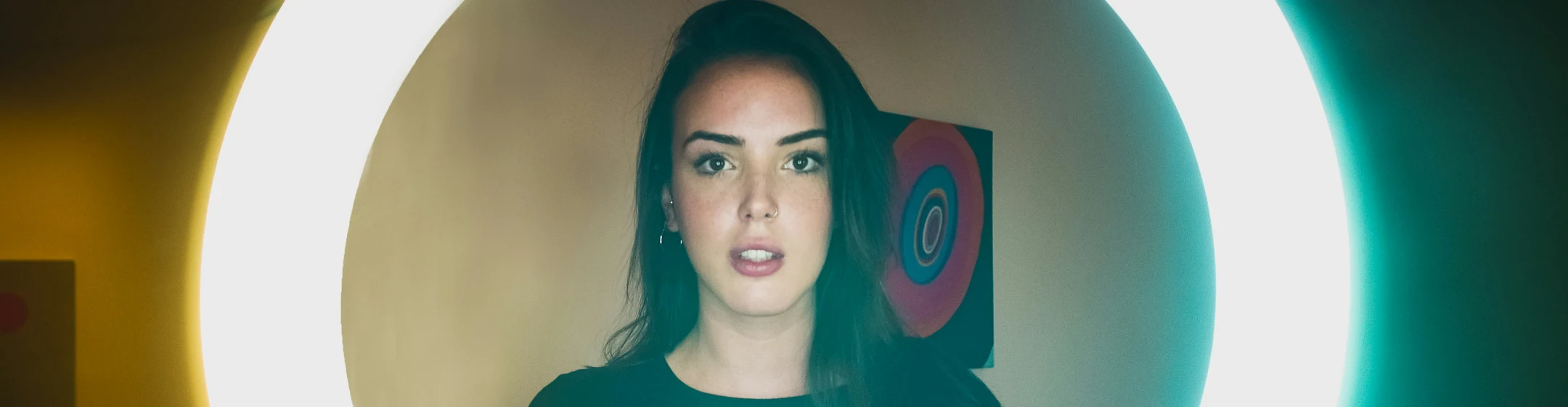 Fansly creator framed by a ring light at her studio setup